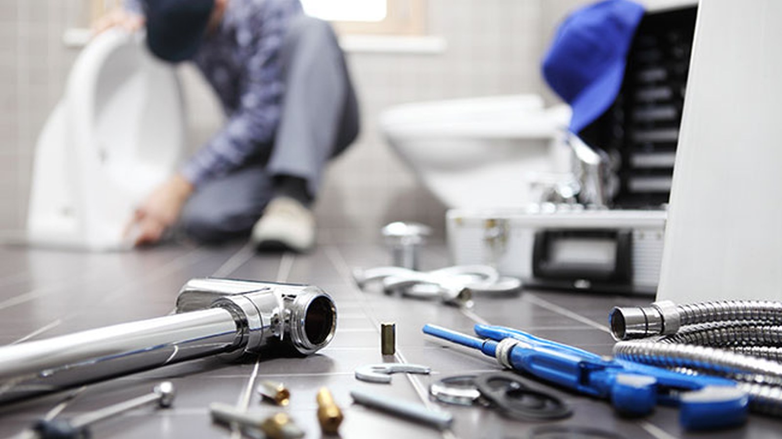 Plumbing tools and fittings on a bathroom floor during a residential plumbing repair, illustrating typical repair timing in Leesburg, VA