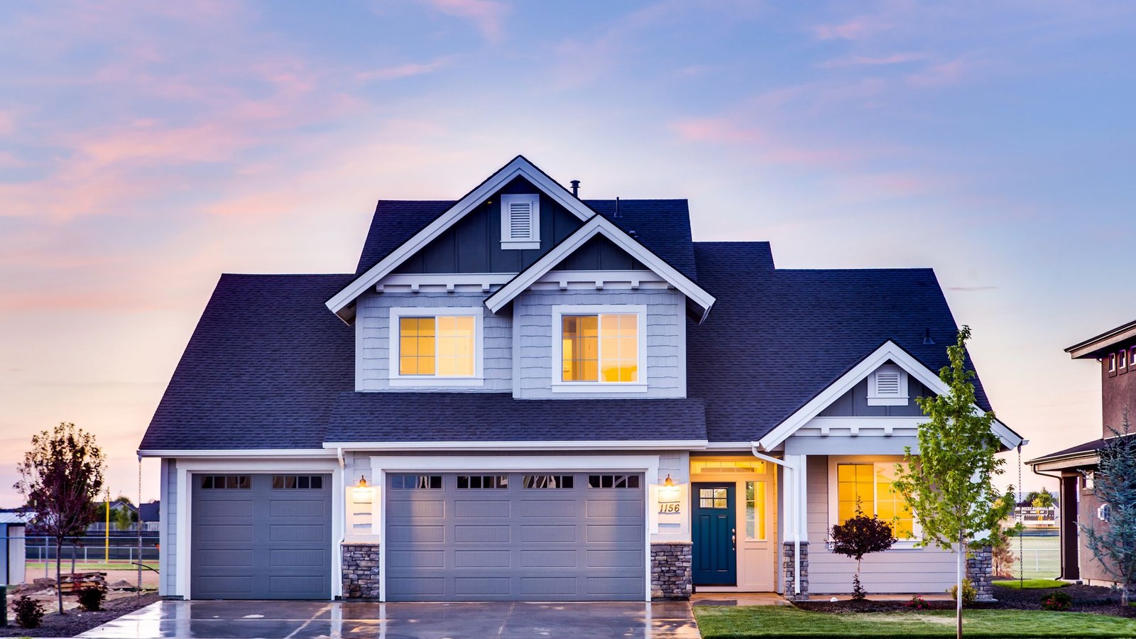 Well-kept two-story suburban home at dusk with warm interior lights, illustrating how plumbing repairs can support home value in Leesburg, VA